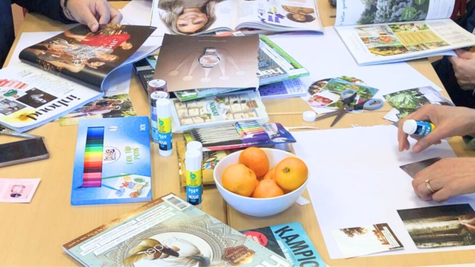 Foto van een tafel vol knutselspullen en tijdschriften. 