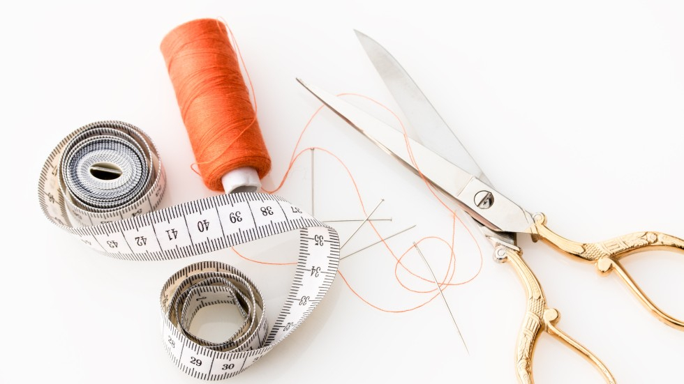 Een schaar, meetlint en naaigaren
