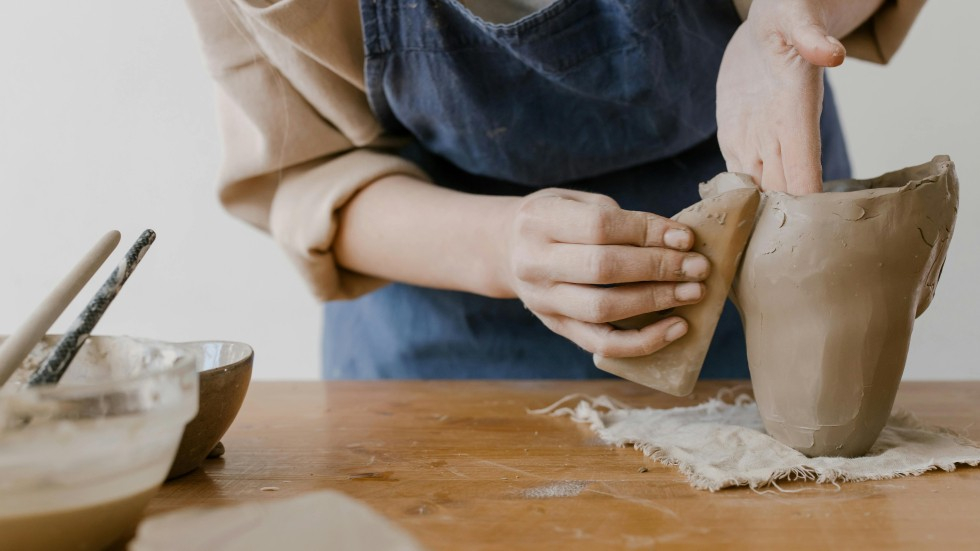 Handen die met keramiek bezig zijn