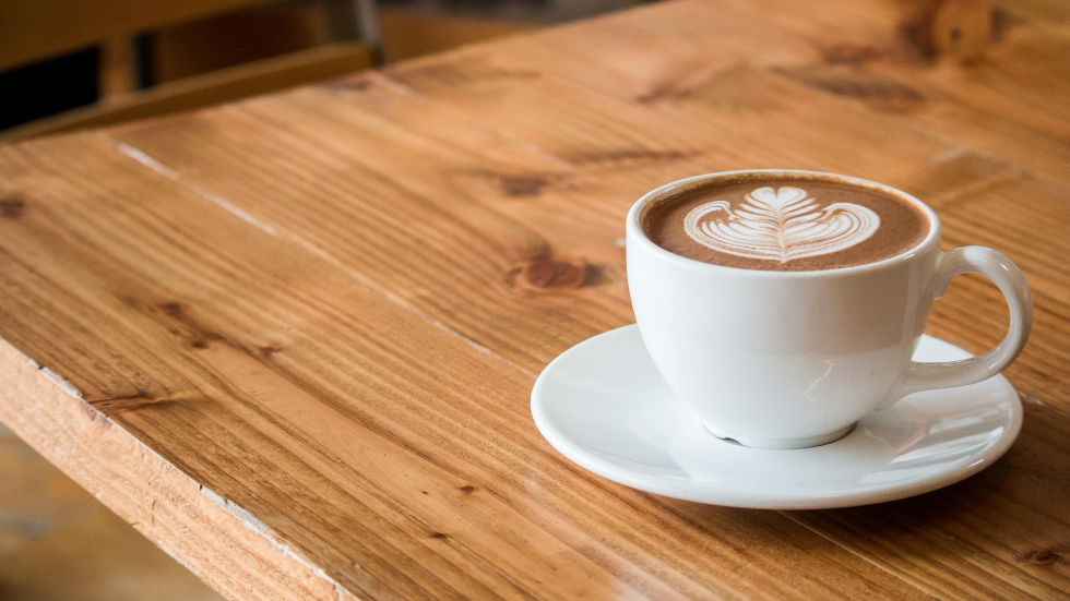 Een kopje koffie op een houten tafel