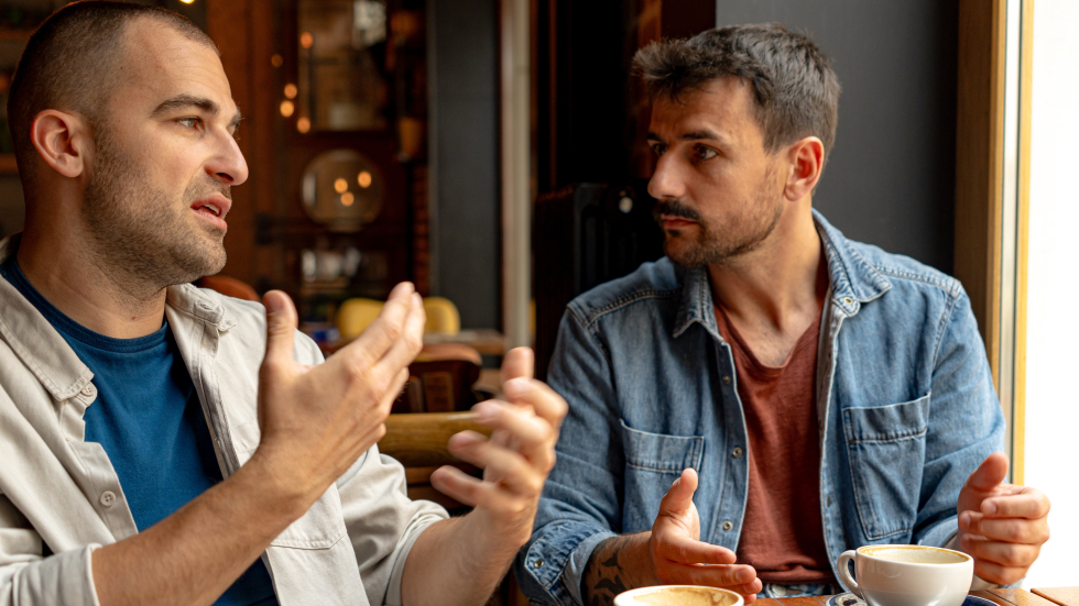 Twee mannen die koffie drinken en met elkaar praten