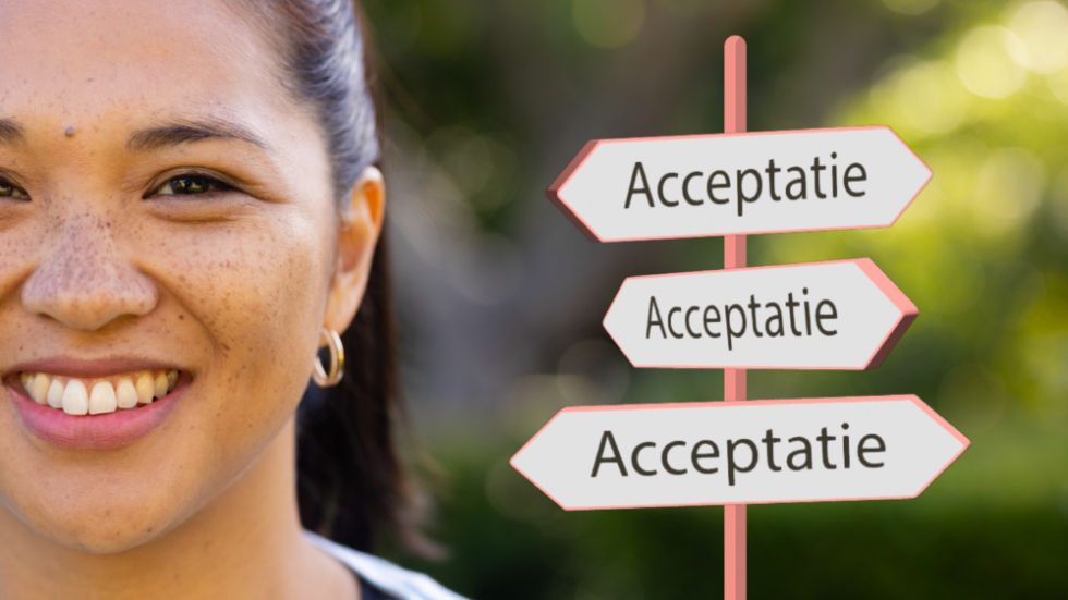 Foto van een lachende vrouw, naast haar wegwijzer bordjes met 'acceptatie' erop