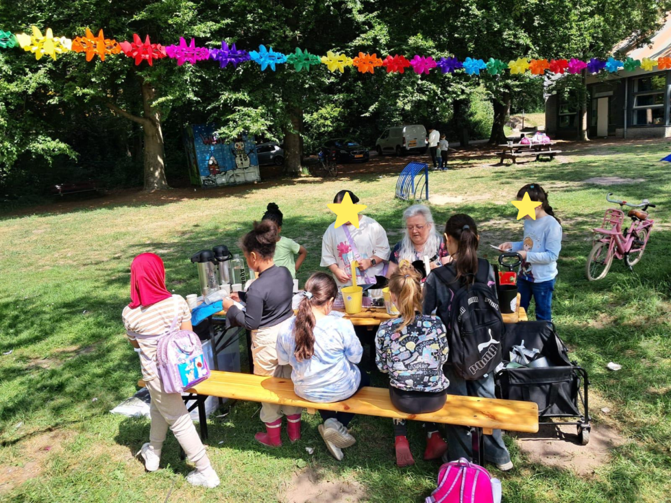 Kinderen zitten aan de picknicktafel in het park