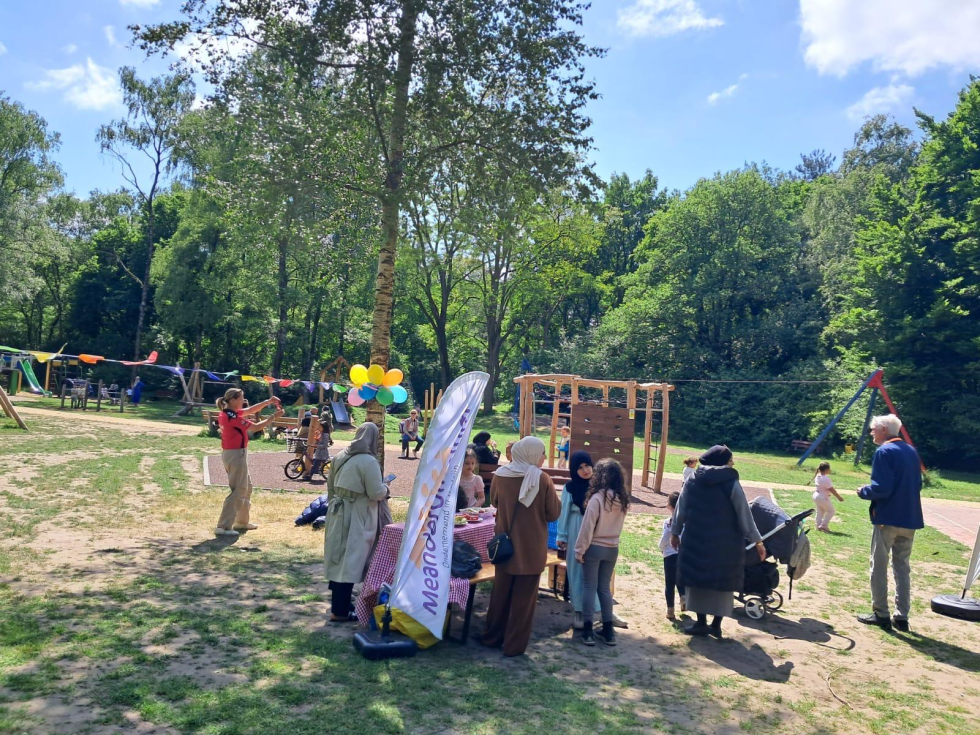 Kinderen spelen in het park, er hangen vlaggetjes en balonnen