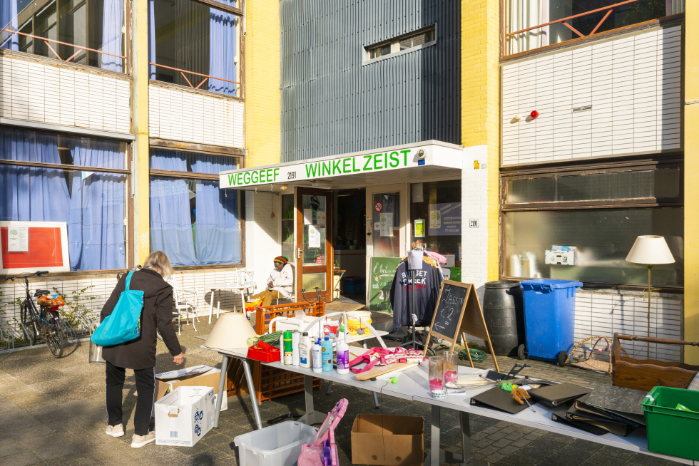 De Weggeefwinkel Zeist. Buiten voor de Weggeefwinkel staan tafels met spullen die men gratis kan meenemen.