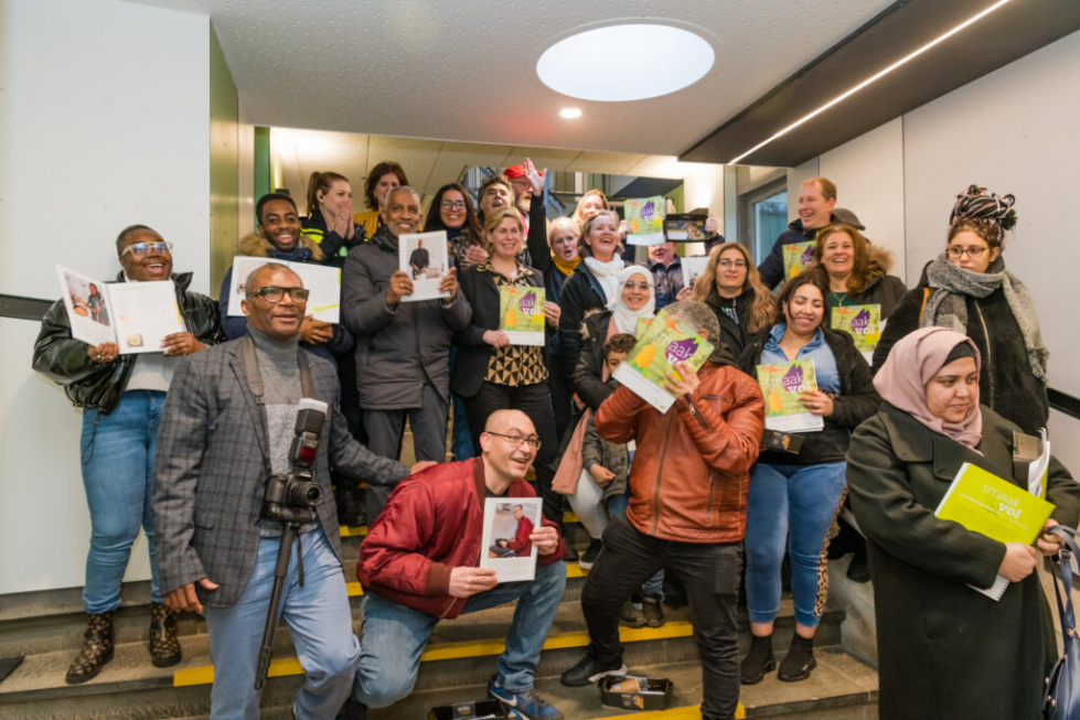 Alle bewoners en betrokkenen die hebben meegewerkt aan het kookboek tijdens de lancering van het kookboek. Ze staan op de foto en hebben allemaal het kookboek vast. 