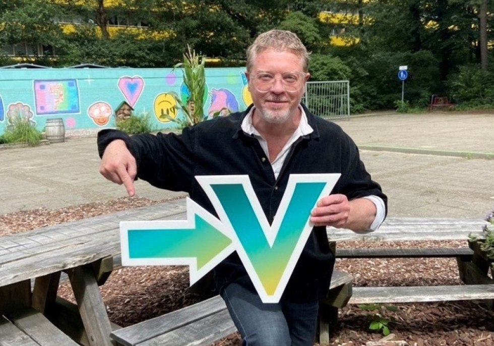 Mark Lotz op 't OntmoetingsPlein met een pijl en een V van Vollenhove Vooruit in zijn handen