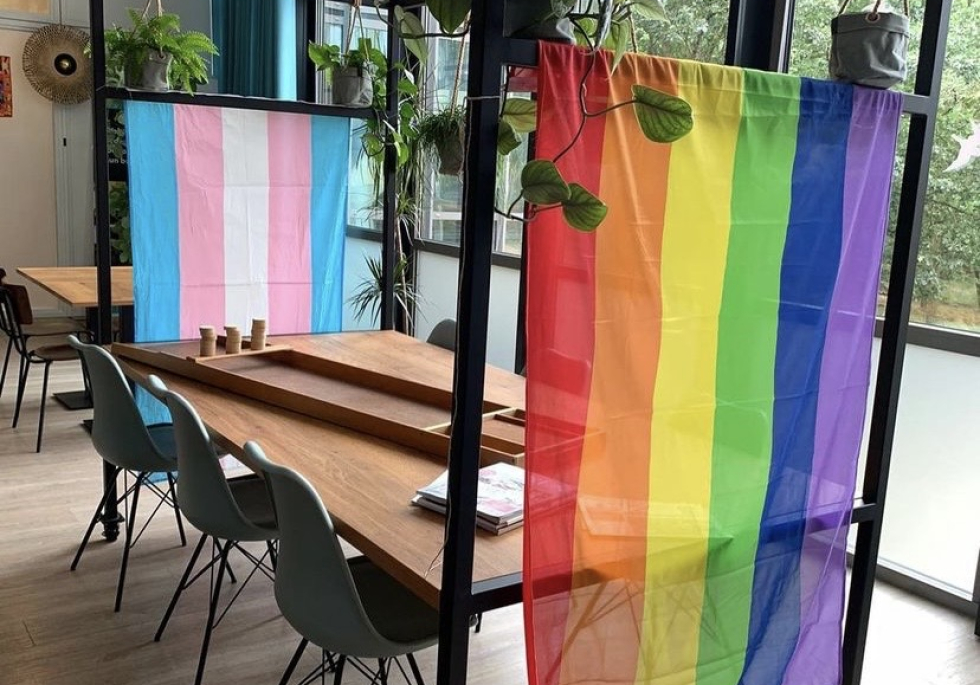 Regenboogvlag en een tafel in 't Volle Hof met daarop een sjoelbak