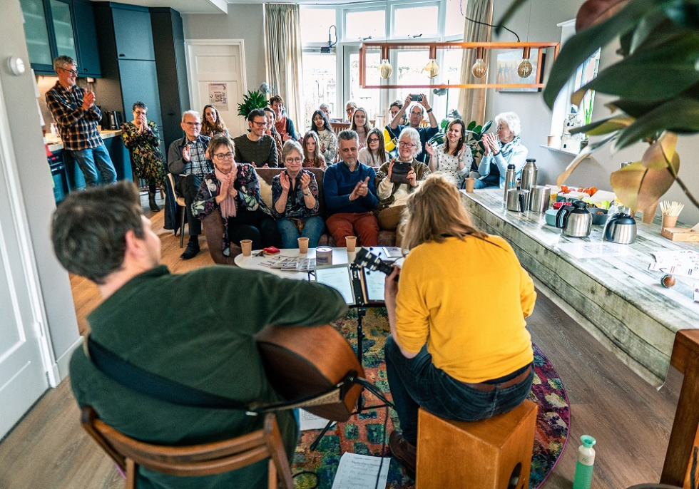 Foto van een concert in een huiskamer tijdens Gluren bij de Buren