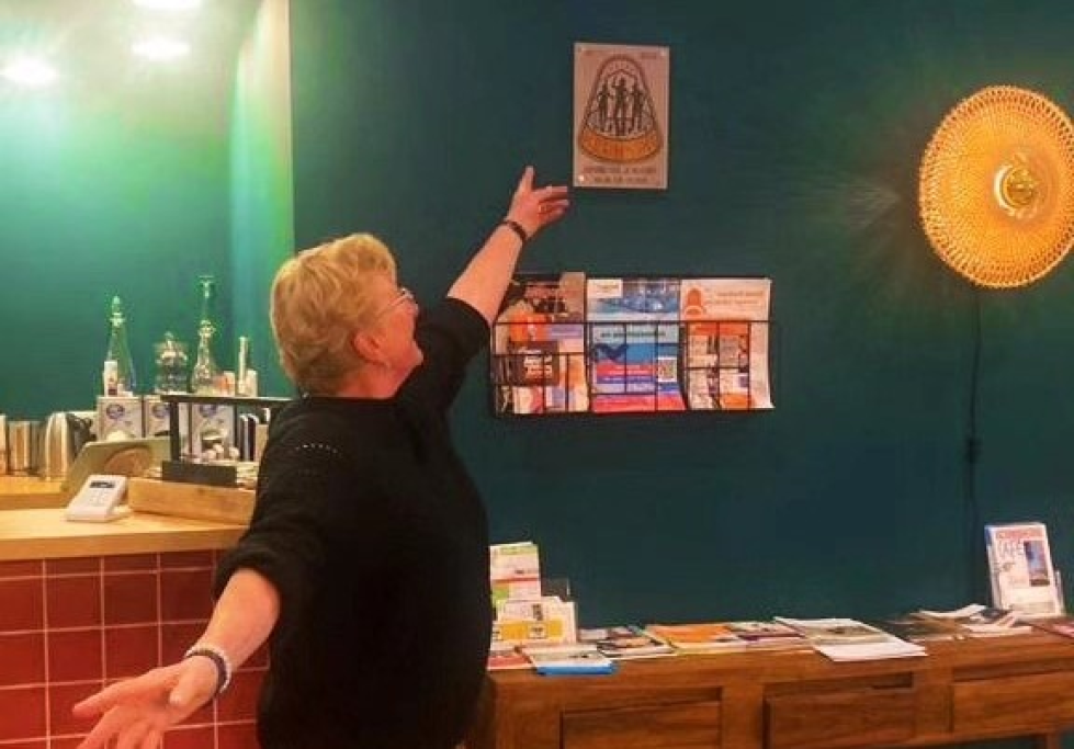 Grietje in 't Volle Hof, wijzend naar de trofee die de Groengroep heeft gekregen en nu aan de muur hangt. 