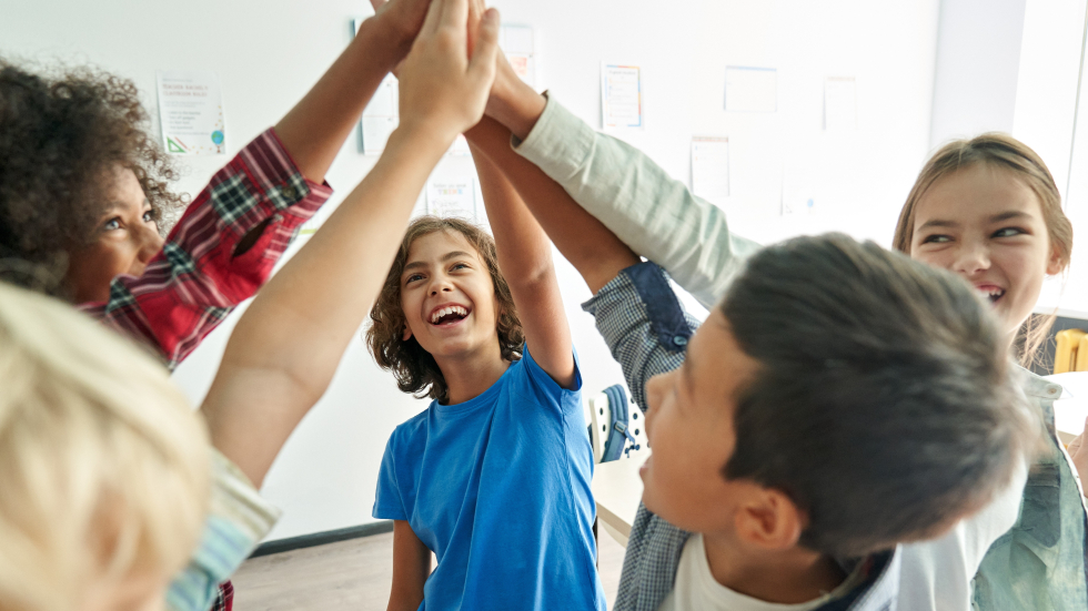 Vijf kinderen geven elkaar een high five 