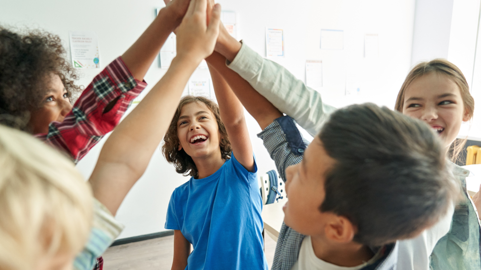 5 kinderen geven elkaar een high five 