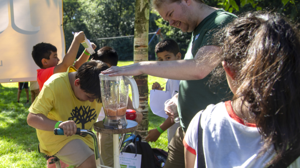 Foto van een kind dat een activiteit op een fiets uitvoert tijdens het vorige Groen doet Goed festival in Bospark Vollenhove