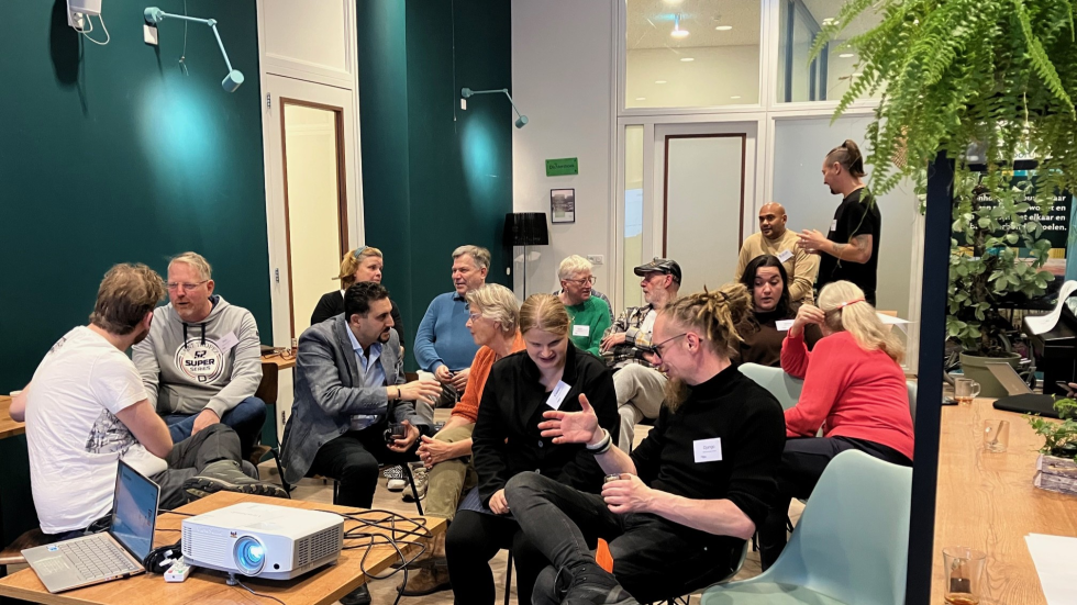 Foto van de deelnemers die met elkaar praten in 't Volle Hof tijdens de bijeenkomst