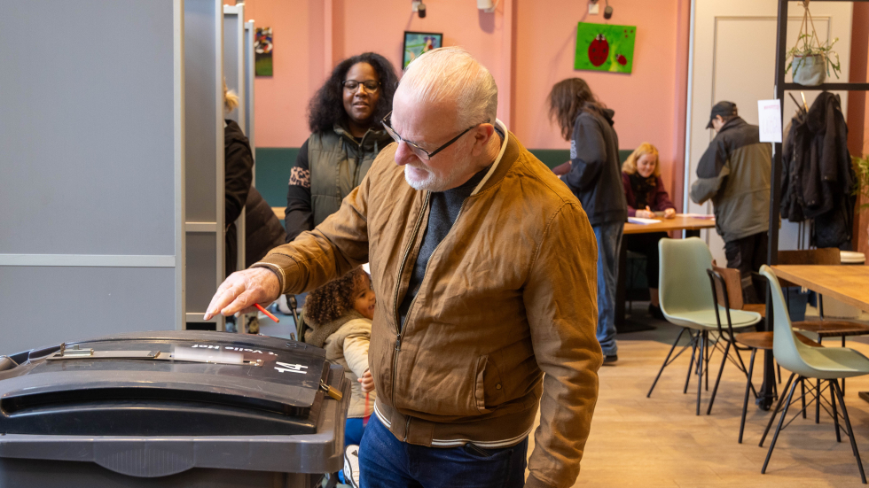 Een man levert een stembiljet in in wijkcentrum 't Volle Hof