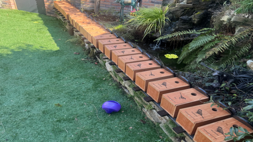 Een rij met vogelhuisjes die klaar liggen in een tuin